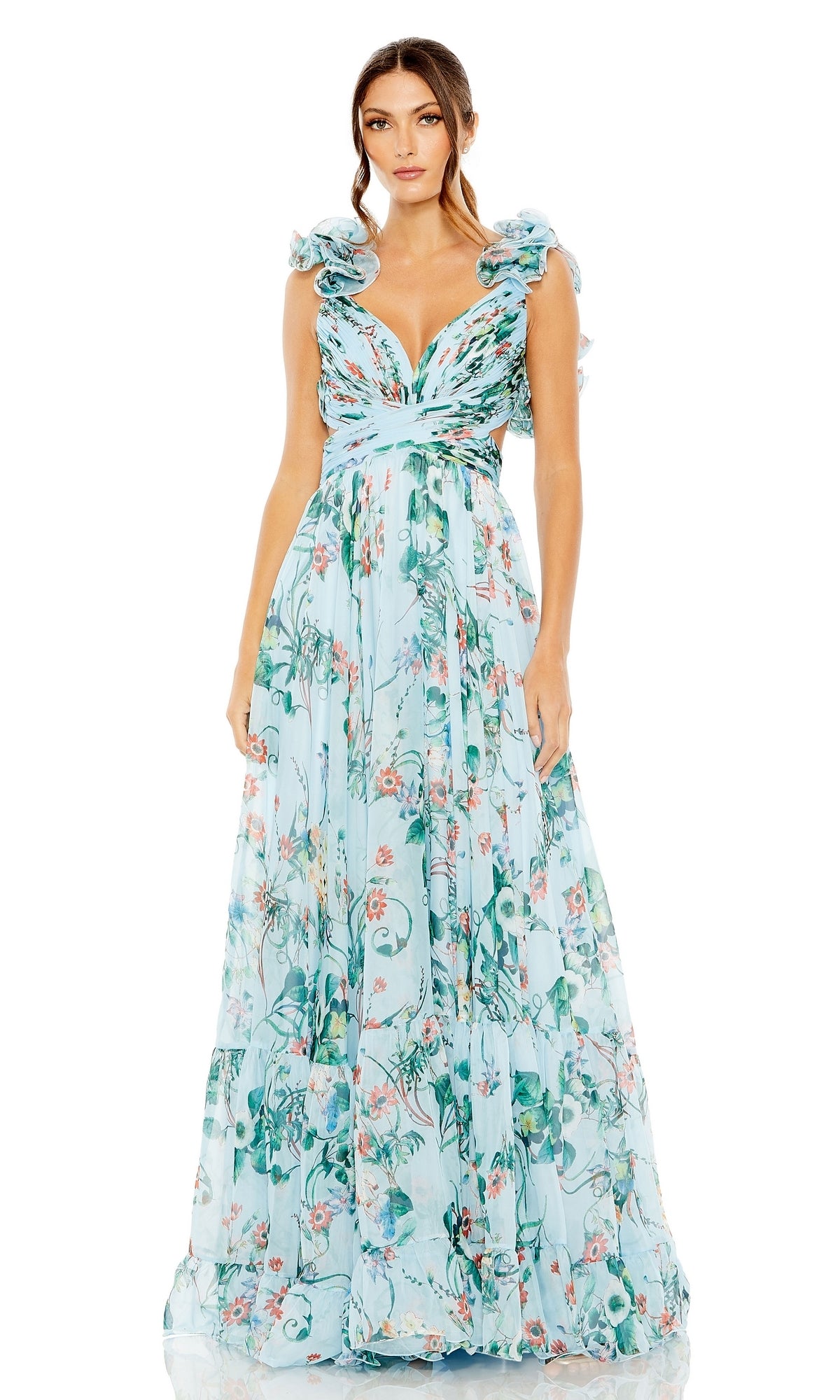 A woman wears the Long Formal Dress 68521 by Mac Duggal—a floor-length, sleeveless light blue A-line dress featuring floral patterns, ruffled shoulders, and a deep V-neckline.